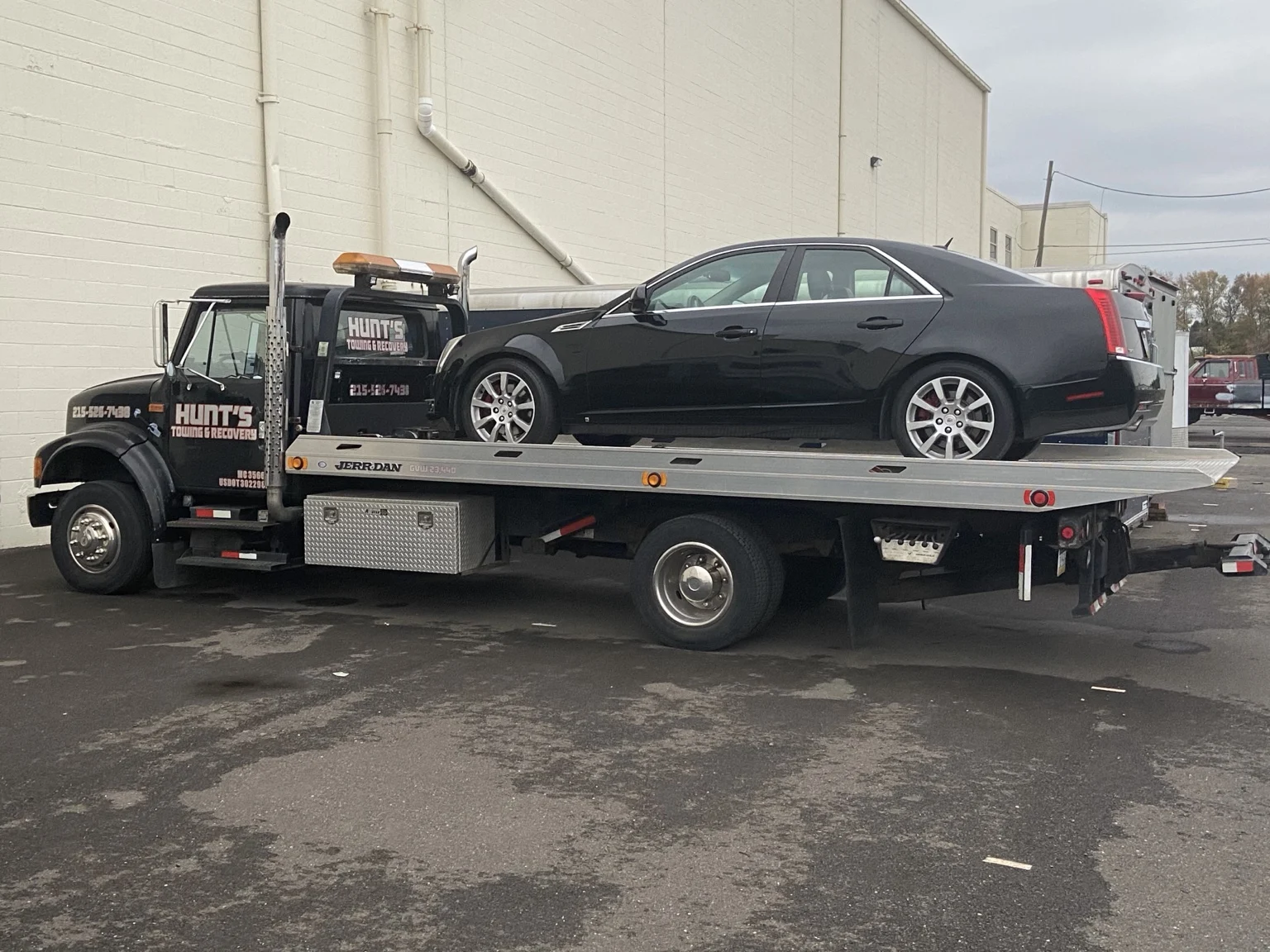 Black sedan being transported on the Hunt’s flatbed