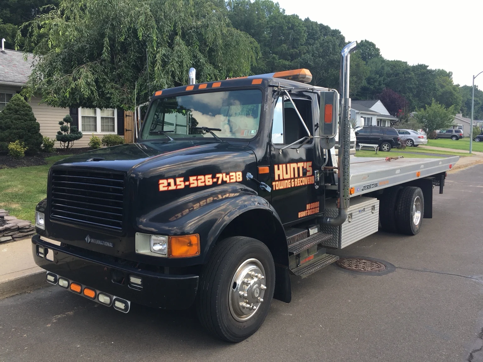 Hunt’s black flatbed tow truck on a neighborhood street