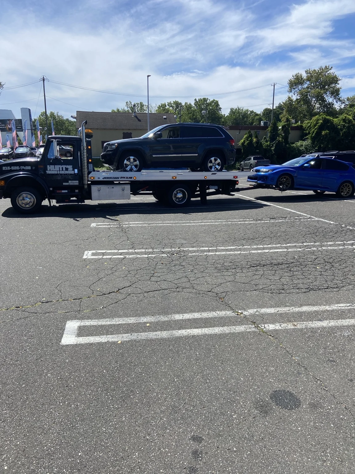 Black SUV on the Hunt’s flatbed with a blue car behind it