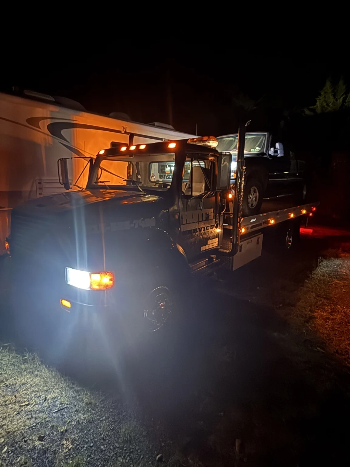 The Hunt’s tow truck with its lights illuminated at night